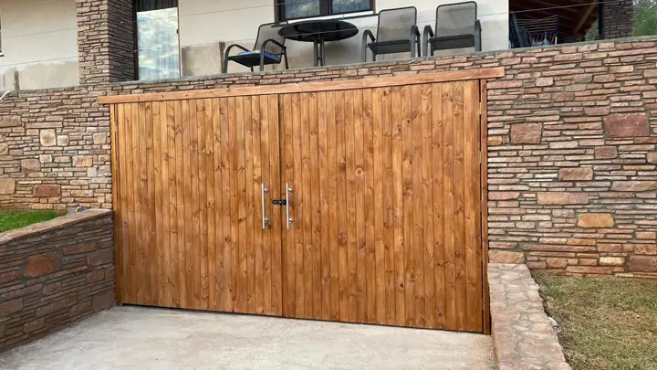 Portón de madera y muro de piedra