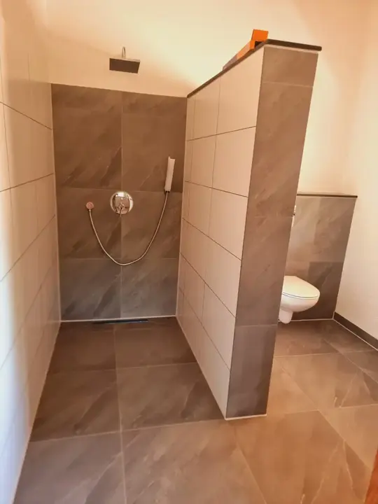 Baño con ducha revestida en porcelanato